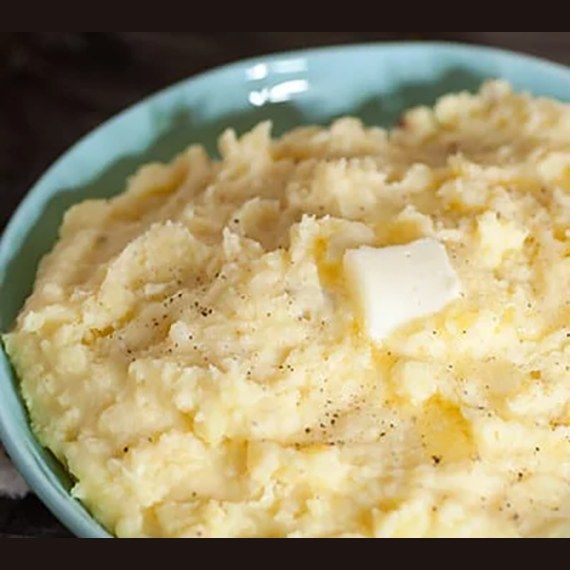 Bowl of creamy mashed potatoes topped with a pat of butter
